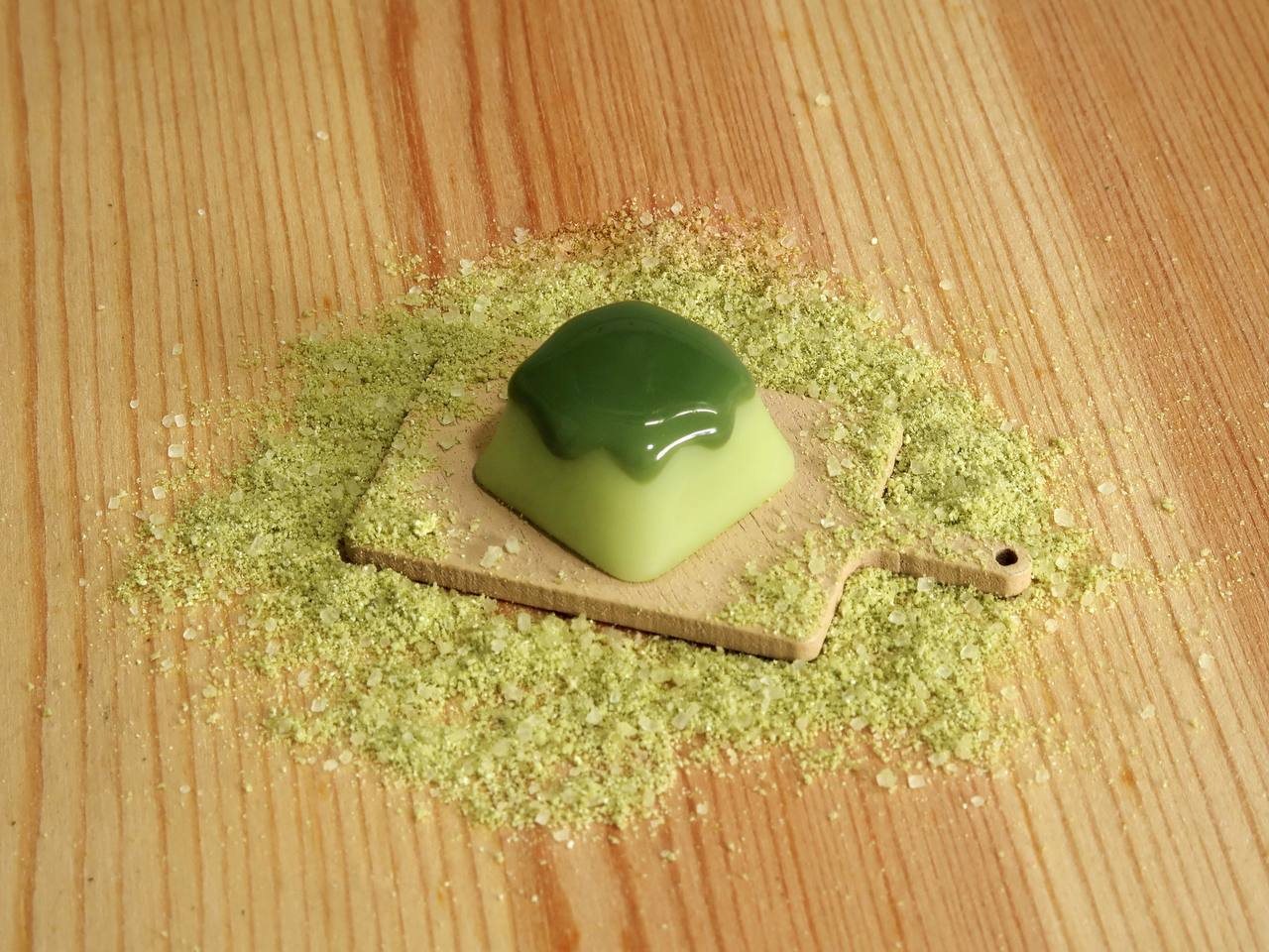 A matcha warabi mochi artisan keycap on a wooden board